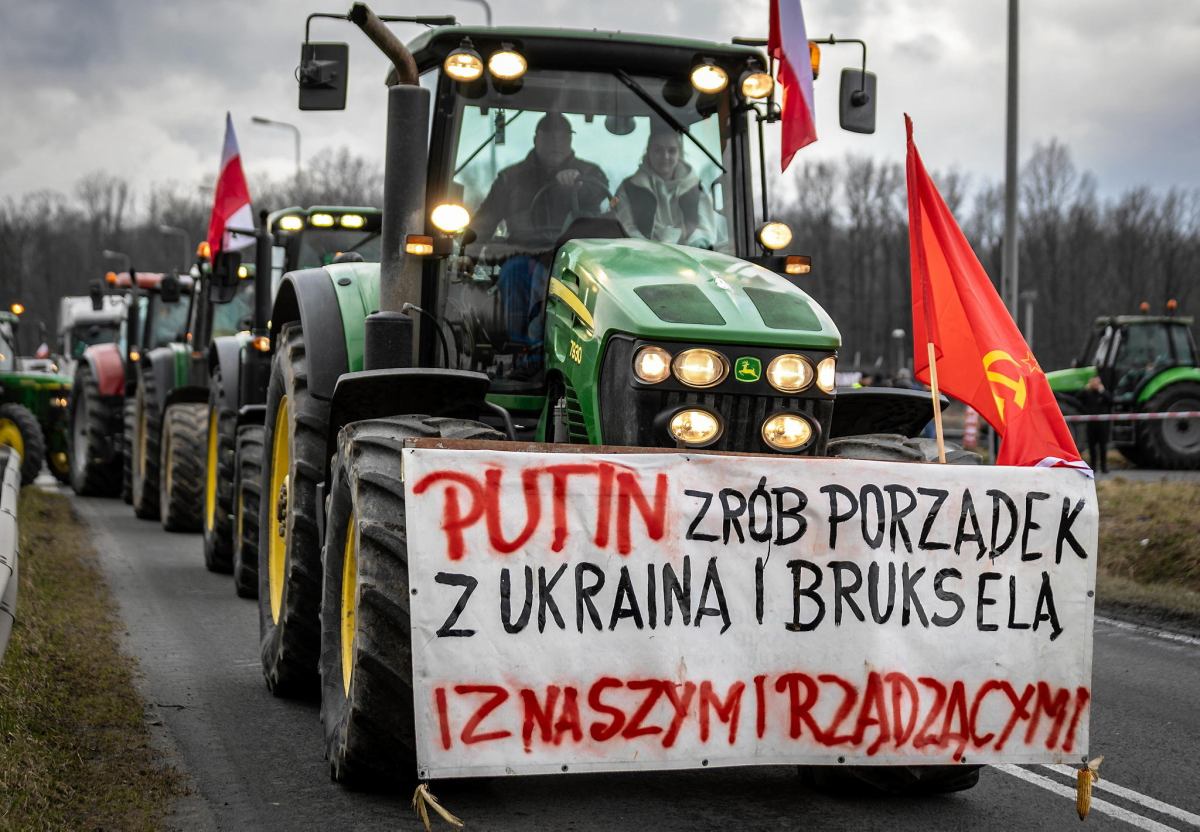 Banner hanging on a tractor saying 'Putin, please clean up Ukraine, Brussels and our own government'